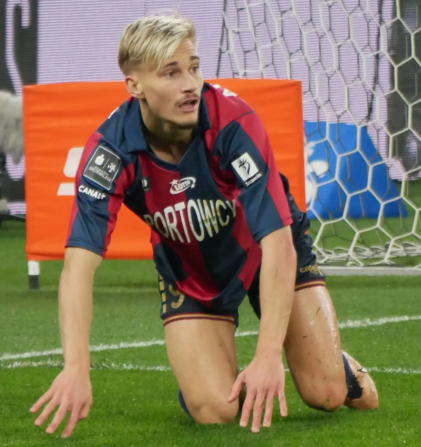 Pontus Almqvist a terra sul terreno di gioco durante una partita con il Pogoń Szczecin
