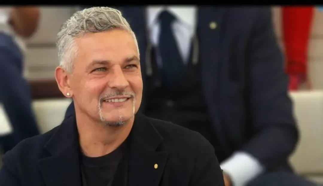 Roberto Baggio sorridente in giacca scura