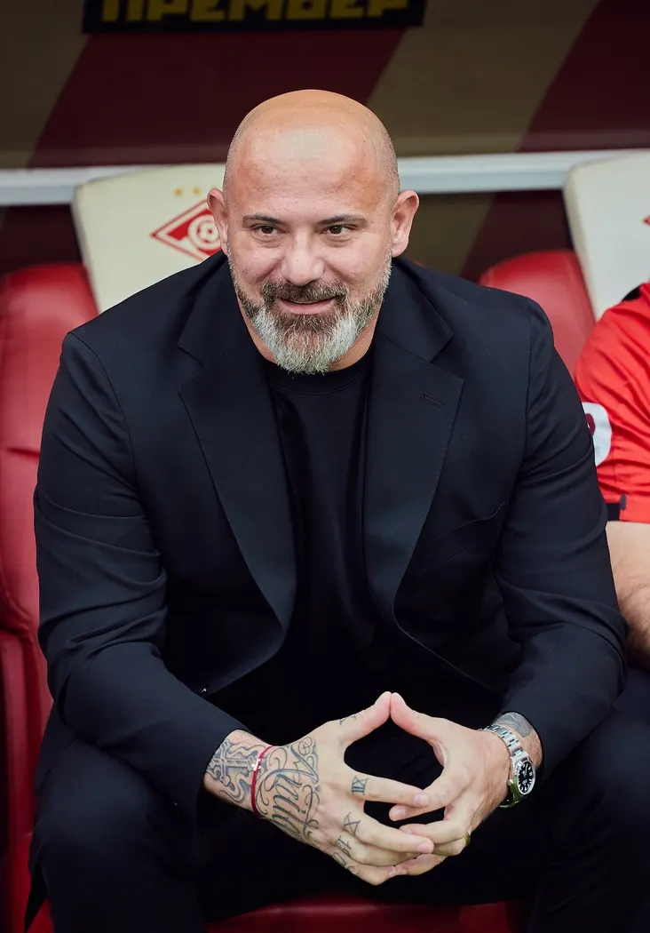 Dejan Stanković in panchina con giacca scura seduto a bordo campo